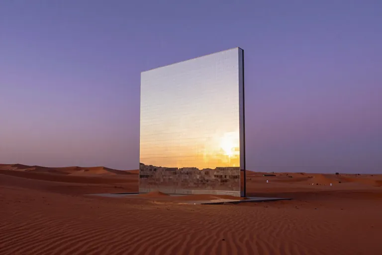 a mirrored monolith in a red desert at golden hour reflecting a purple sky, wide cinematic, ultra sharp